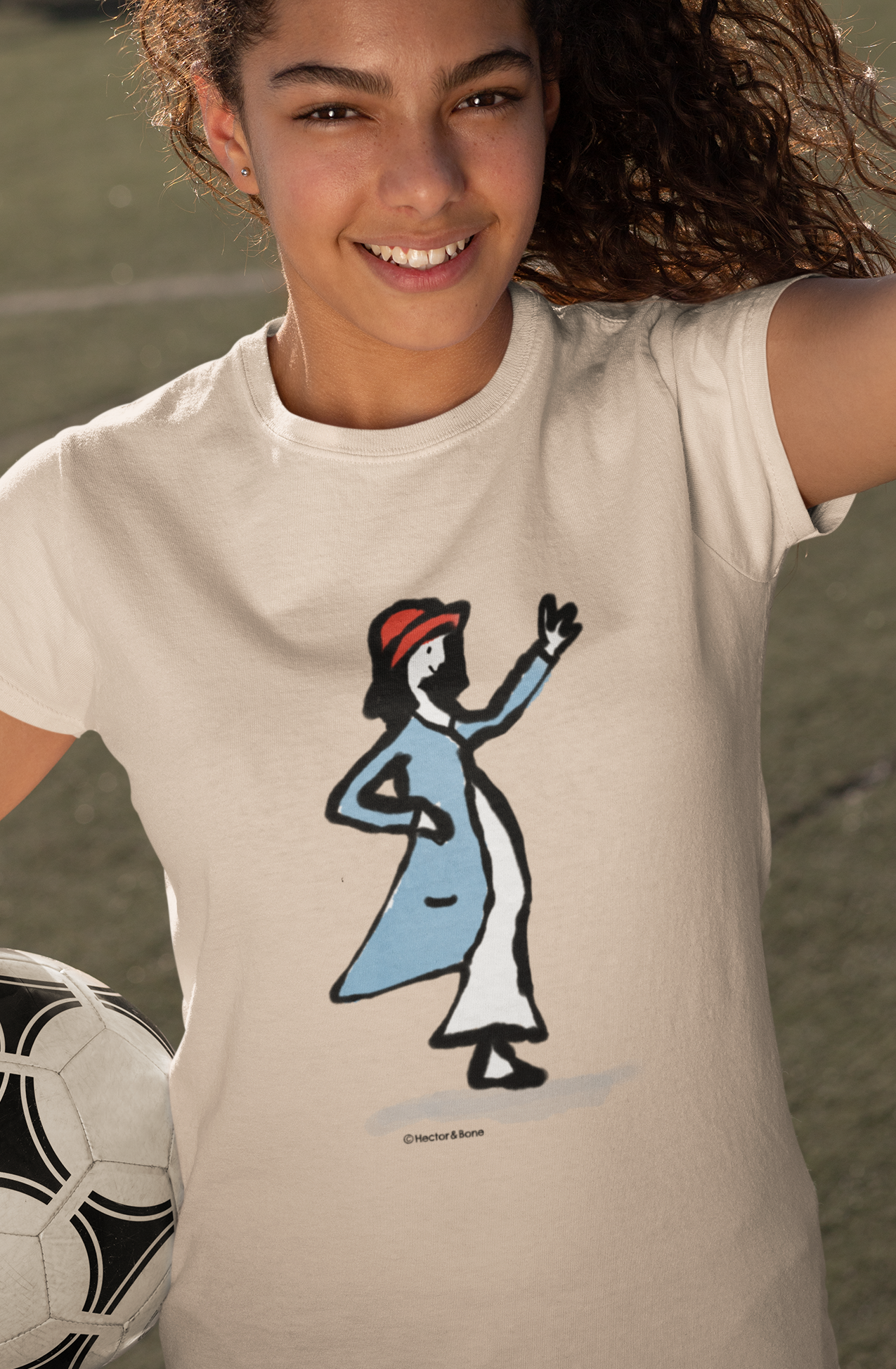Happy young soccer girl wearing an illustrated waving girl t-shirt on heather rainbow vegan cotton tshirt by Hector and Bone