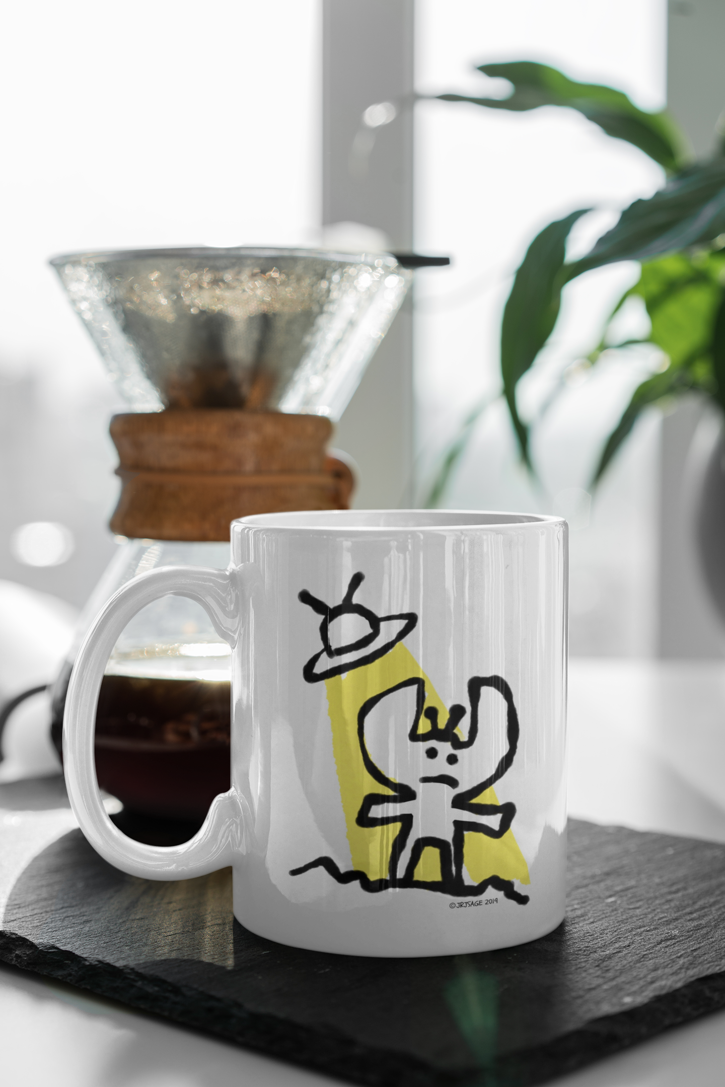 A White Ceramic Hector and Bone Mug with an illustration of a cute Alien and his Spaceship