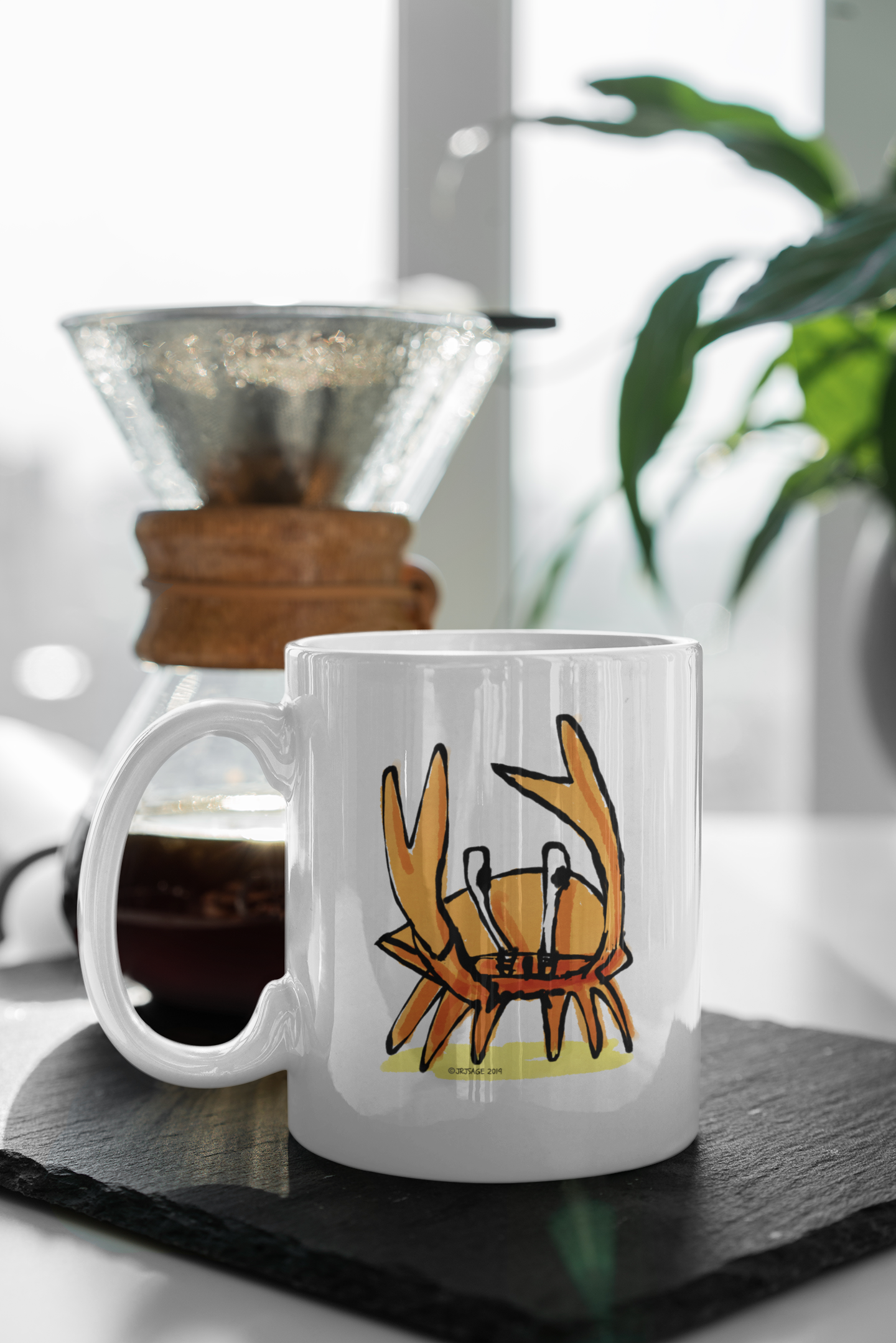 A White Ceramic Hector and Bone Mug with an illustration of a cute Angry Crab on a table
