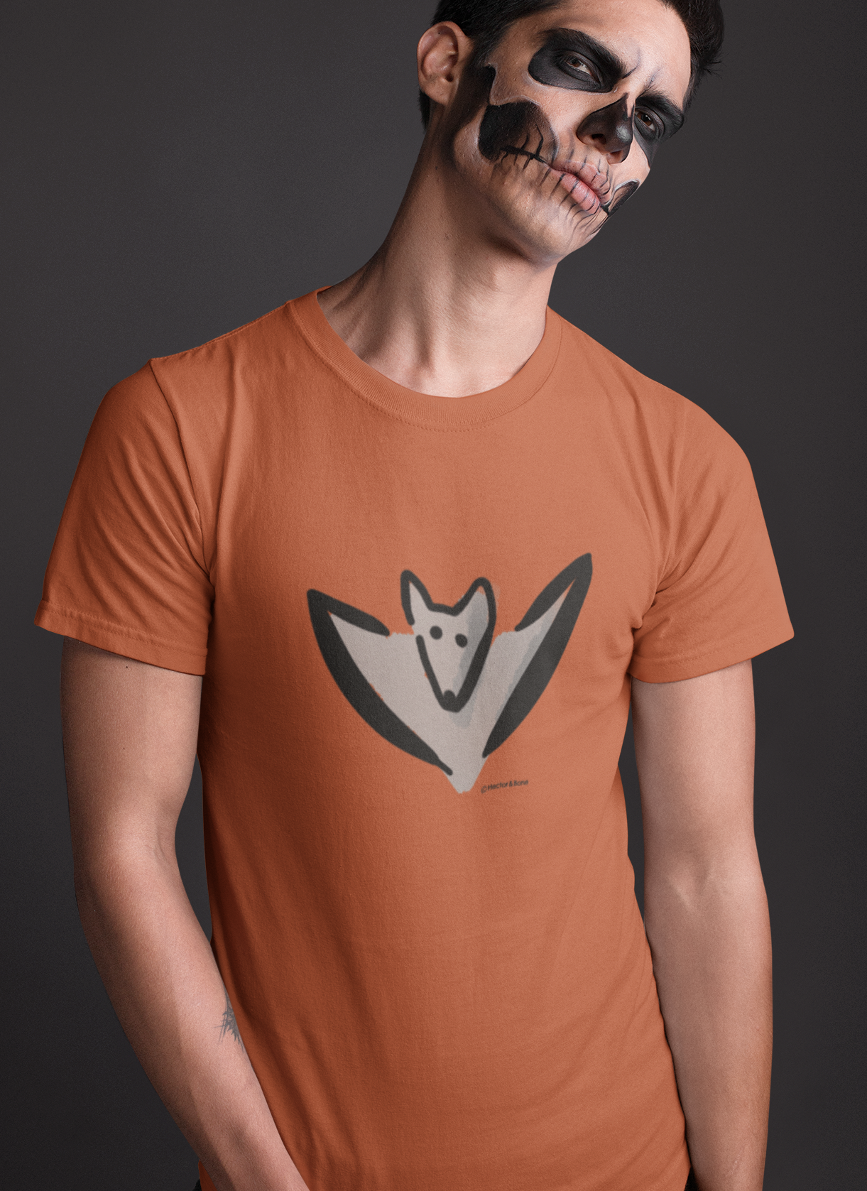 Bat T-shirt - Young man wearing an illustrated Bertie Bat T-shirt for Halloween in pumpkin orange colour vegan cotton tshirts by Hector and Bone
