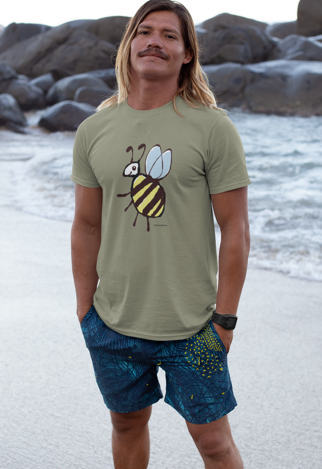 Bee T-shirt - Young man on beach wearing a cute Busy Bee illustrated heather grey vegan cotton t-shirts by Hector and Bone