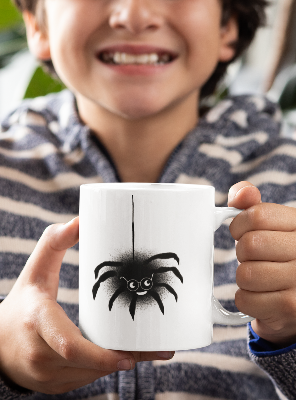 Young boy holding Spencer Spider Halloween illustrated design coffee mug by Hector and Bone