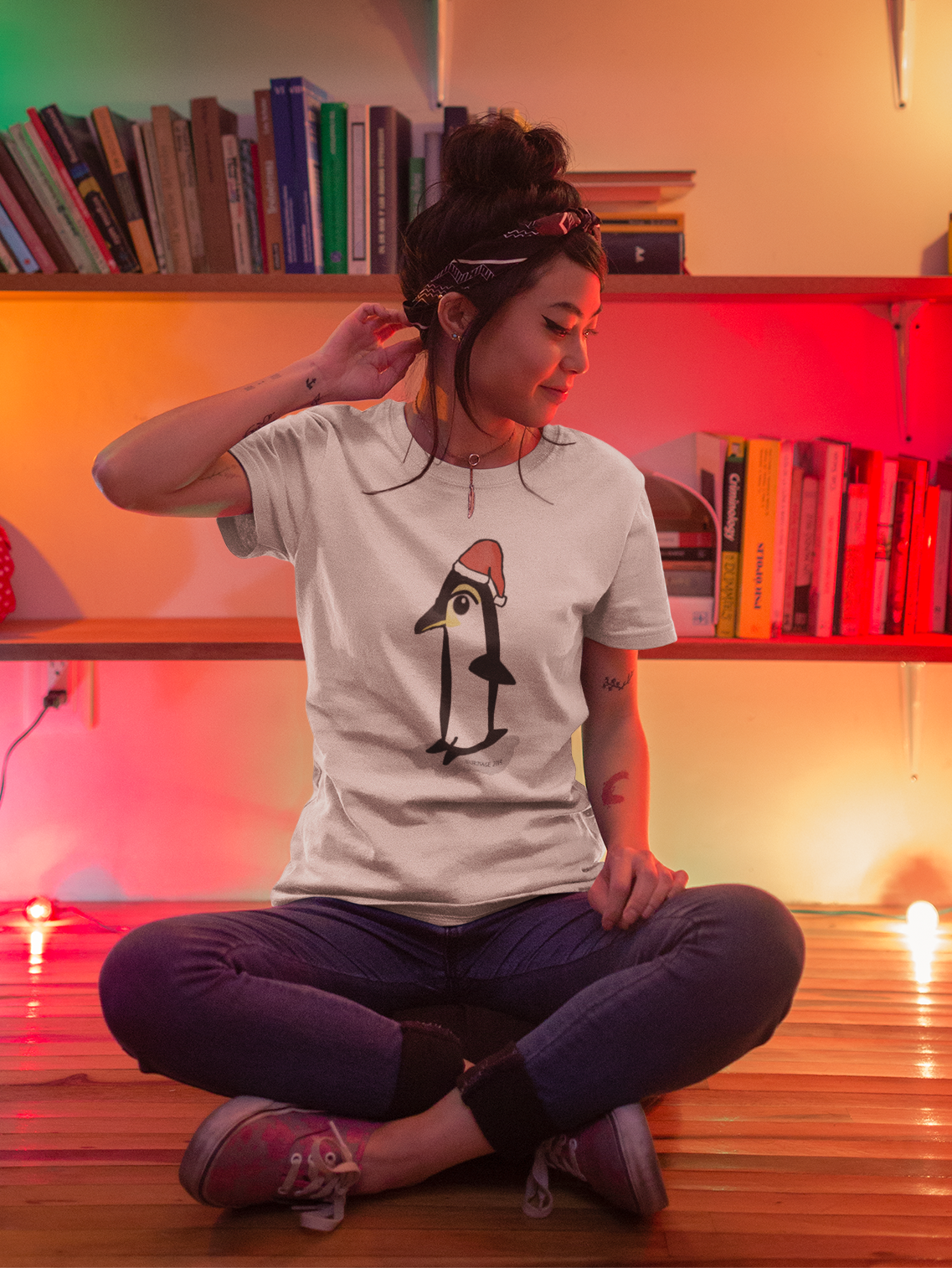 Young woman wearing a Santa Penguin cute Christmas T-shirt illustrated design by Hector and Bone on a Vegan cotton t-shirt