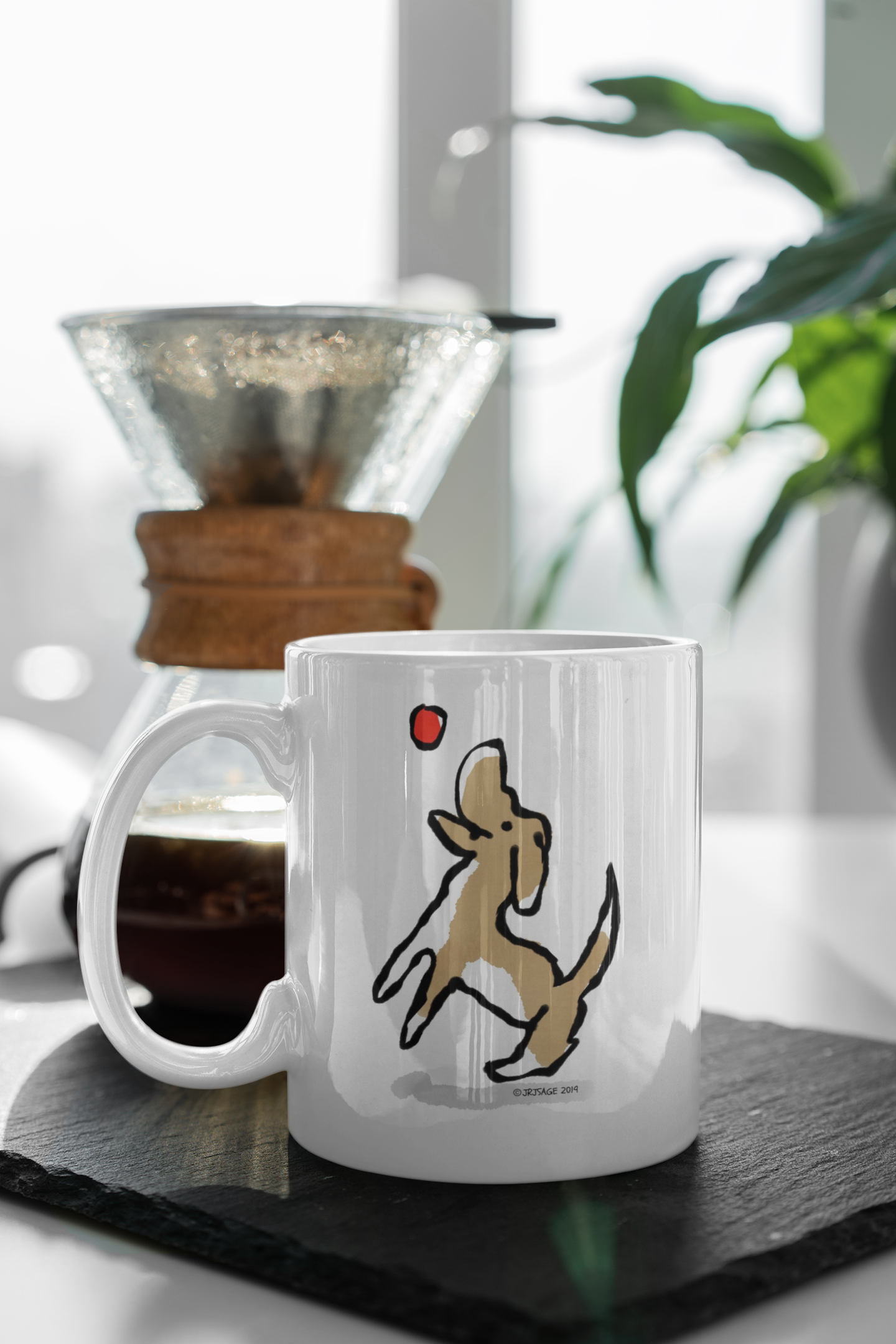 Jumping Dog mug puppy with ball illustration by Hector and Bone on a table