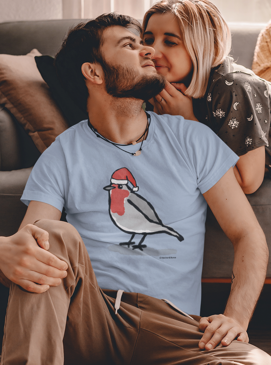 Young man and woman relaxing at Xmas, wearing an illustrated Santa Christmas Robin T-shirt - Sky Blue colour vegan cotton Christmas T-shirts by Hector and Bone