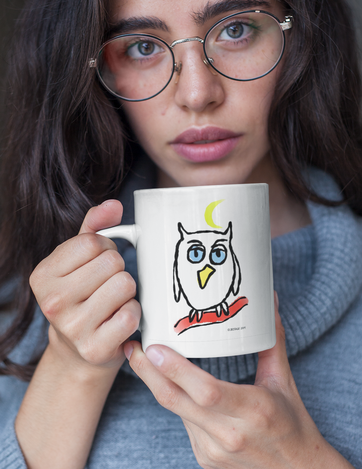 Young woman holding a ceramic white Hector and Bone mug with a cute Night Owl illustration