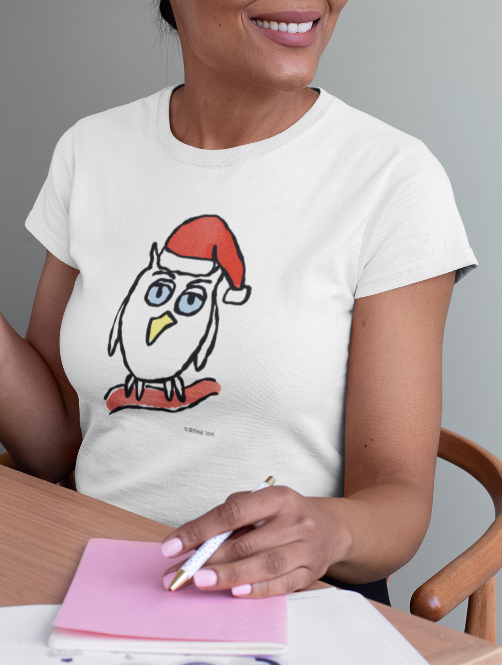 Woman wearing a Santa Night Owl cute Christmas T-shirt illustrated design by Hector and Bone on a vegan cotton t-shirt