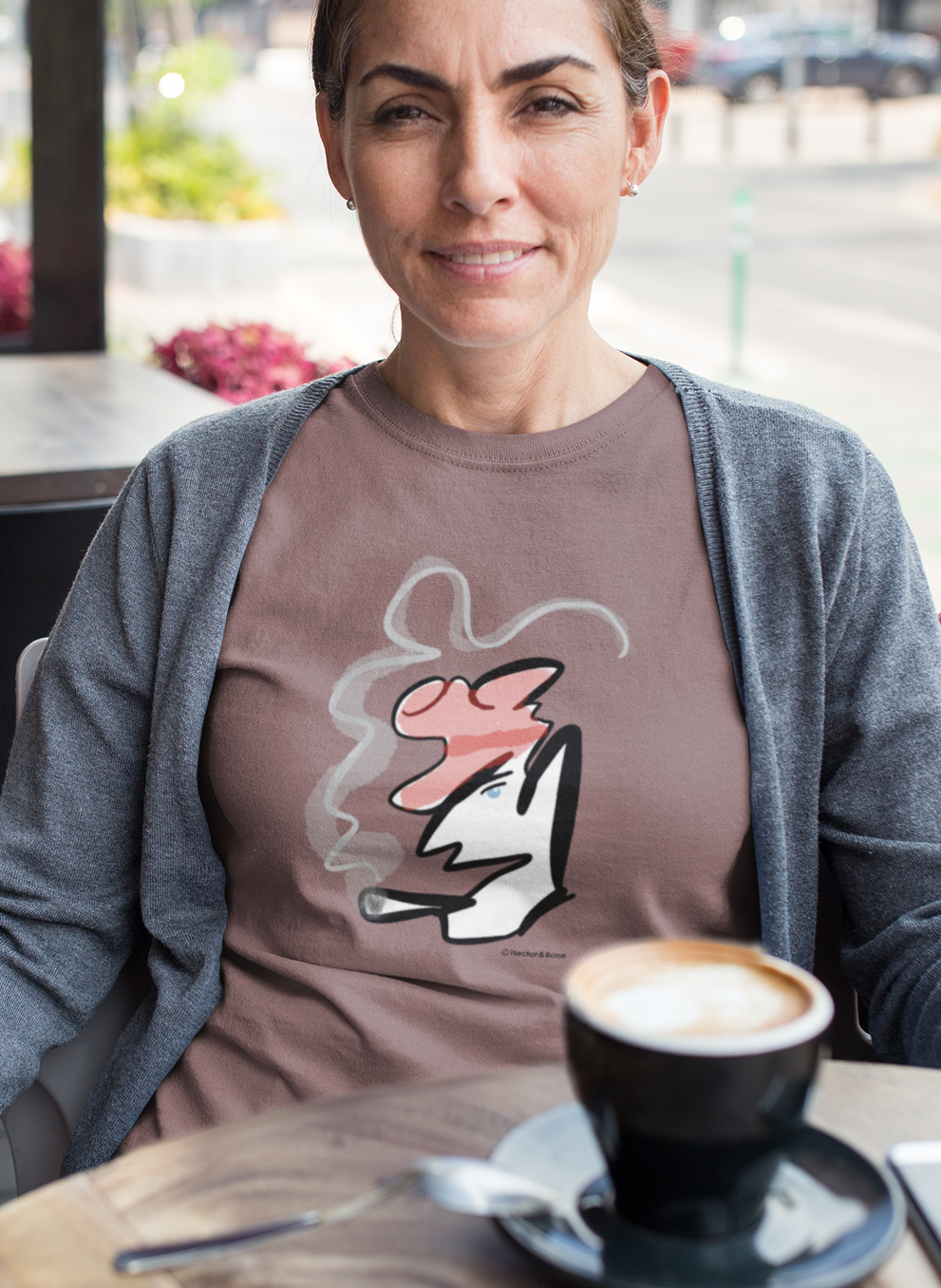 Woman wearing a stylised illustrated design of Parisian smoking man portrait on a coffee colour vegan cotton t-shirt by Hector and Bone