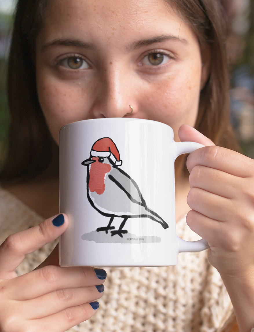 Young woman sipping from a Santa Robin Christmas mug design by Hector and Bone cute Robin bird wearing an Xmas hat