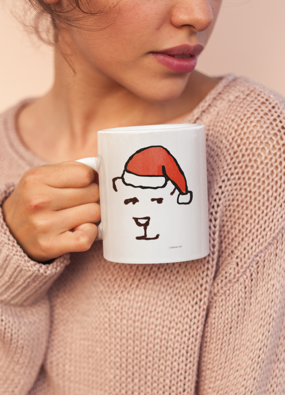 Young woman holding a Santa Polar Bear Christmas mug design by Hector and Bone - A cute bear wearing a Santa hat